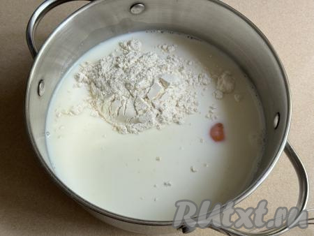 В кастрюлю влить молоко, добавить сахар, ванильный сахар и сырое яйцо, всыпать муку.