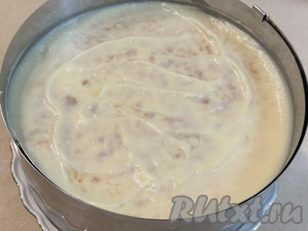 Теперь можно приступать к сборке торта из творожных коржей, приготовленных на сковороде, и заварного крема. Для этого нужно взять плоскую тарелку, на неё поставить кулинарное кольцо (или разъёмную форму) соответствующего диаметра, выложить первый корж, хорошо промазать его частью заварного крема, выложить сверху следующий корж, слегка прижать, тоже хорошо смазать его частью заварного крема, таким образом, чередуя коржи и крем, собрать весь торт. Верхний корж тоже смазать кремом.