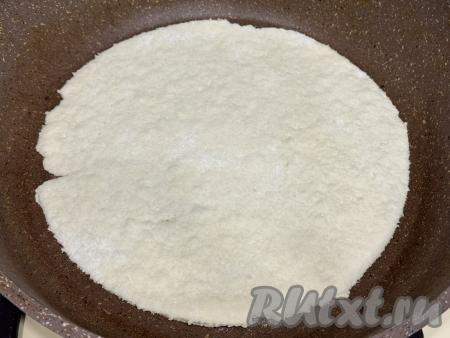 Сухую (не смазанную маслом) сковороду хорошо разогреть. Выложить одну часть раскатанного теста на сухую горячую сковороду. Сковорода должна быть диаметром не меньше, чем диаметр раскатанного теста (то есть диаметр сковороды должен быть не менее 24 сантиметров).