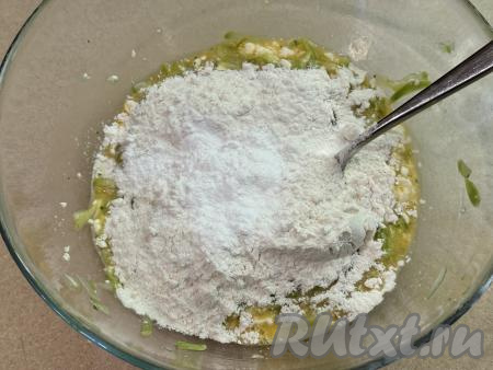 В миску с получившейся творожно-кабачковой массой всыпать весь разрыхлитель и 1 столовую ложку муки, перемешать тесто для вафель ложкой до однородности. Затем понемногу добавлять оставшуюся муку, каждый раз полностью вмешивая её и контролируя густоту замешиваемого теста.