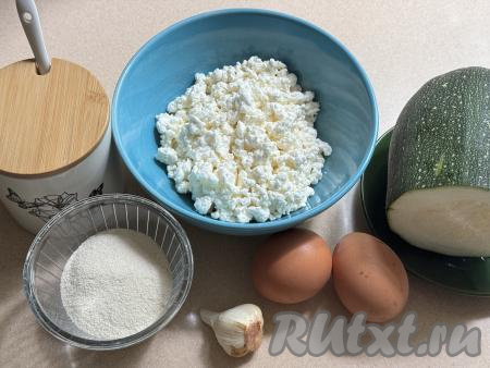 Подготовить продукты для приготовления запеканки из кабачка и творога в аэрогриле. Кабачок очистить от кожуры, если семечки крупные, их нужно будет удалить вместе с рыхлой мякотью. Для запеканки нам потребуется 200 грамм подготовленного кабачка. Чеснок почистить. Творог можно взять любой жирности и консистенции (я купила жирностью 9%).&nbsp;