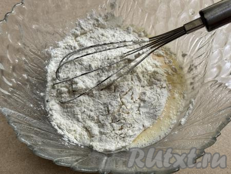Начать частями всыпать муку, каждый раз полностью перемешивая тесто венчиком до однородности и контролируя густоту теста.&nbsp;