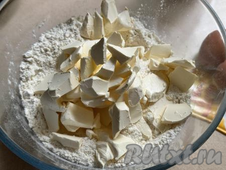 Сливочное масло достать из холодильника, нарезать на небольшие кусочки, добавить в миску с сухими ингредиентами.&nbsp;