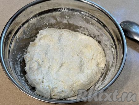 Начать добавлять оставшуюся муку по половине столовой ложки, каждый раз полностью вмешивая её. Вначале перемешивать тесто столовой ложкой. А после того как перемешивать ложкой станет сложно, начать замешивать его руками, добавляя муку только по мере необходимости. Добавляя муку, учитывайте, что итоговое творожное тесто для хачапури должно получиться мягким, слегка липнущим. Как только добились нужной консистенции творожного теста, значит больше муку добавлять не нужно. Количество муки, которое придётся добавить в творожное тесто, зависит и от влажности творога, и от размера яичных белков, и от качества самой муки.