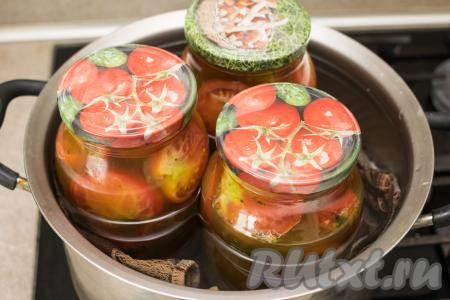 На дно объёмной кастрюли (я взяла кастрюлю объёмом 6,5 литров) выложить полотенце (или тряпочку, сложенную в 2-3 слоя). Благодаря ткани, находящейся на дне кастрюли, дно банок не будут касаться кастрюли, поэтому баночки не лопнут в процессе стерилизации. В кастрюлю поверх полотенца (или тряпочки) поставить банки с помидорами. Влить в кастрюлю столько воды, чтобы она доходила до "плечиков" банок. Поставить кастрюлю с банками с помидорами на средний огонь. После закипания воды в кастрюле уменьшить немного огонь, стерилизовать литровые банки с помидорами по-болгарски в течение 10 минут.