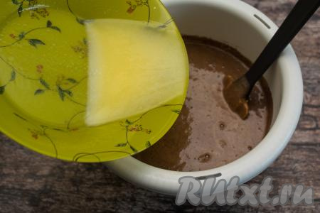 В получившуюся яично-шоколадную массу влить негорячее растопленное сливочное масло, перемешать до получения однородной массы.