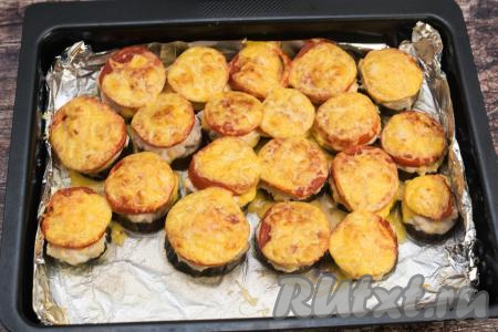 Запекать кружочки из баклажанов под помидорами и сыром в духовке ещё 10 минут (до расплавления сыра).