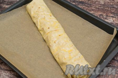 Желток, который мы выложили в чашку, взболтать кулинарной кисточкой до однородности. А затем с помощью кисточки смазать поверхность штруделя желтком.