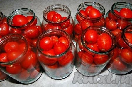 Теперь наполнить стеклянные банки помидорами. Банку всё время нужно встряхивать, чтобы помидоры плотнее укладывались.