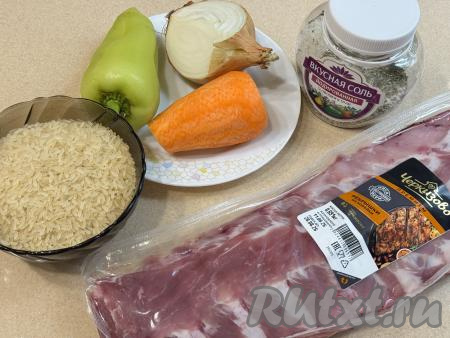 Подготовить продукты для приготовления свиных рёбер с рисом в духовке. Рис тщательно промыть водой, лишней воде дать стечь. Лук и морковь почистить. Из болгарского перца удалить плодоножку с семенами. Свиные рёбра промыть водой, обсушить.
