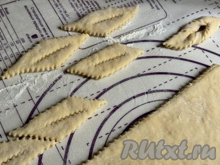 С помощью ножа (у меня - нож для фигурной нарезки) нарезать тесто на полоски шириной примерно 2,5 сантиметра. Получившиеся полоски разрезать на части длиной примерно 8 сантиметров. Получатся заготовки вергунов. В середине каждой получившейся заготовки сделать разрез.