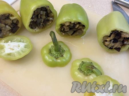 Срезать у каждого болгарского перца "верхушку" (веточку я решила оставить). Удалить семена из перца, промыть водой. Болгарский перец наполнить начинкой из жареных баклажанов, прикрыть ранее отрезанной "верхушкой".&nbsp;
