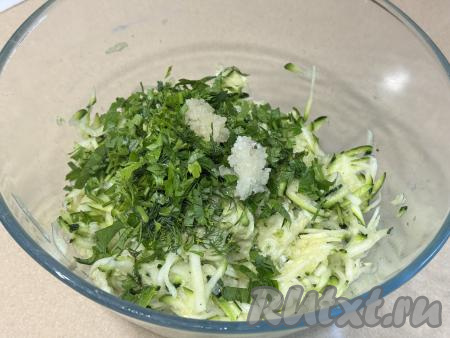В миску с отжатой кабачковой массой добавить мелко нарезанную зелень и пропущенный через пресс чеснок.