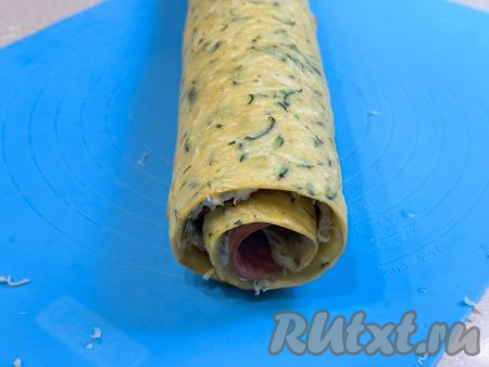 Свернуть кабачковый корж с начинкой в плотный рулет, начиная со стороны с колбасой. Сформированный рулет завернуть в фольгу и поместить в холодильник на 2-3 часа, чтобы он хорошо пропитался.