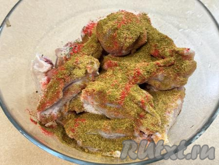 Куриные крылья, нарезанные на части, выложить в глубокую миску, всыпать соль и специи (у меня - паприка, карри и хмели-сунели).&nbsp;