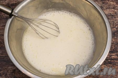После того как сода погасится в кефире, получившуюся смесь из кефира и соды влить в миску со взбитыми яйцами, перемешать кефирно-яичную смесь венчиком до однородности.