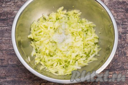 Кабачок очистить от кожуры. Если семечки у кабачка крупные, их обязательно нужно будет удалить вместе с рыхлой мякотью. 450 грамм подготовленного кабачка натереть на крупной тёрке в глубокую миску, всыпать соль, перемешать и оставить минут на 10, чтобы из кабачка выделился сок.