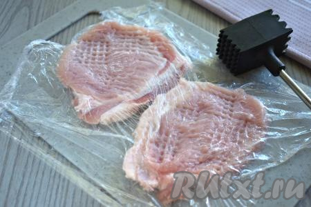 Мякоть свинины (у меня - карбонат) и шампиньоны моем, обсушиваем. Нарезаем мясо на 2 одинаковых по размеру куска. Для того чтобы не пачкать рабочую поверхность, куски свинины&nbsp;перед отбиванием я накрываю пищевой плёнкой. Кухонным молотком для мяса отбиваем куски свинины с двух сторон до толщины 0,7-1 сантиметр.