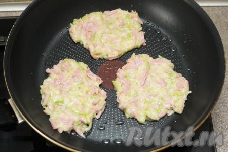 В сковороду влить немного растительного масла, хорошо прогреть его на огне выше среднего. Выкладывать по 1-1,5 столовых ложки теста из кабачков и сосисок, формируя плоские округлые оладьи.