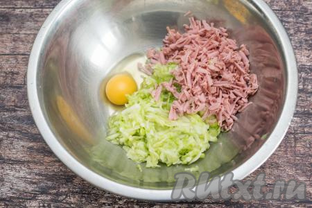 В миску с отжатой кабачковой массой добавить натёртые сосиски, вбить сырое яйцо.