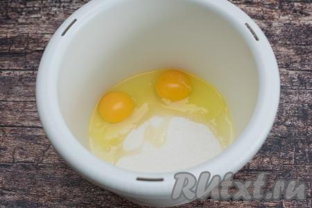 В чашу для взбивания миксером (или в другую достаточно глубокую ёмкость) вбить сырые яйца, сразу всыпать сахар.