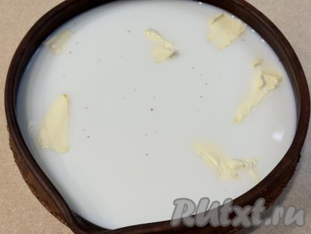 В форму с пшеном влить молоко, выложить кусочки сливочного масла.