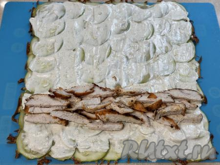 Куриное мясо нарезать на тонкие кусочки, выложить ближе к одной стороне кабачкового коржа.