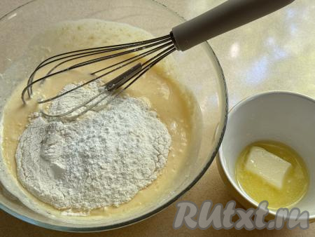 Сливочное масло растопить (лучше растапливать до жидкого состояния), дать немного остыть. В миску с творожной массой всыпать 50 грамм муки и весь разрыхлитель.
