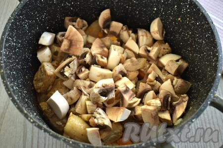 К свинине, обжаренной с овощами, добавляем шампиньоны (или лесные грибы), нарезанные на части, перемешиваем. Обжариваем 7-8 минут, время от времени помешивая.