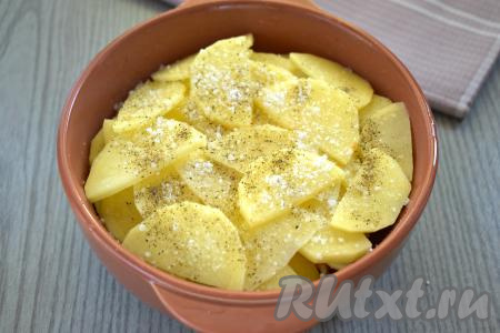 Картошку очищаем, нарезаем на кружочки (или полукружочки) толщиной 3-4 миллиметра, выкладываем в форму для запекания поверх моркови. Солим слой картофеля, немного приправляем специями (я посыпала чёрным молотым перцем).