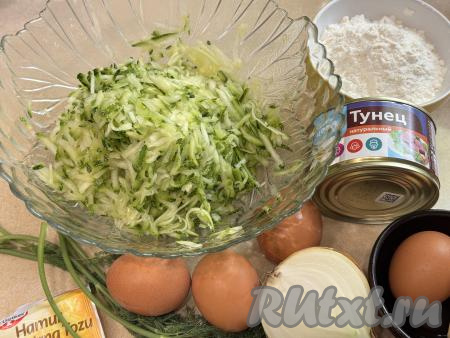 Подготовить продукты для приготовления запеканки из кабачков с тунцом в духовке. Для этого блюда я взяла кабачок с тонкой кожурой и мелкими семечками, поэтому просто тщательно вымыла его и отрезала "кончики" с двух сторон. Если вы возьмете кабачок с толстой кожурой, её нужно будет срезать. Если у кабачка будут крупные семечки, их нужно будет удалить вместе с рыхлой мякотью. 470 грамм подготовленного кабачка натереть на крупной тёрке в достаточно глубокую миску, всыпать 0,5 чайной ложки соли, перемешать и оставить на 10 минут, чтобы из кабачка выделился сок.&nbsp;