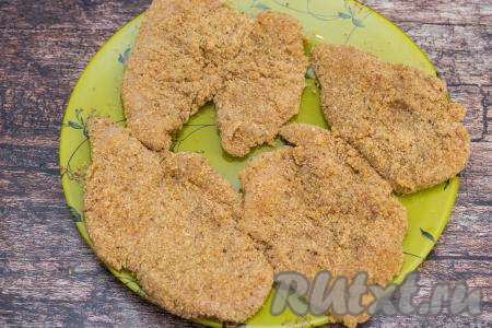 Готовую заготовку куриного лангета выложить на плоскую тарелку. Постепенно покрыть яичным кляром и обвалять в панировочных сухарях все лангеты из курицы, выкладывая их на тарелку.