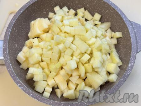 Яблоки очистить от кожуры, нарезать на небольшие кубики, удаляя семенную коробочку с семечками. Нам потребуется 300 грамм нарезанных яблок. В сковороду выложить сливочное масло, немного разогреть на среднем огне, добавить нарезанные яблоки.