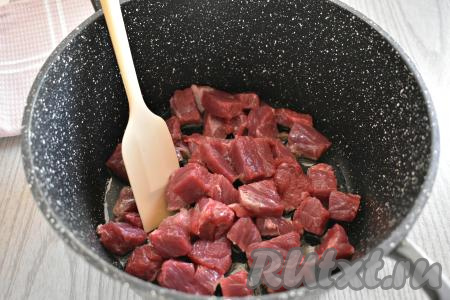 Мякоть говядины моем, обсушиваем, нарезаем на брусочки (или небольшие кубики) толщиной примерно 1 сантиметр. В кастрюле с толстым дном (или в глубокой сковороде) прогреваем растительное масло. Выкладываем в горячее масло нарезанную говядину и обжариваем её на огне выше среднего 8-10 минут (до появления румяной корочки на мясе со всех сторон), периодически перемешивая.