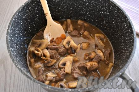 Затем к говядине, обжаренной с шампиньонами и овощами, вливаем 200 миллилитров горячей воды, приправляем специями (я взяла готовую приправу для мяса), перемешиваем. Даём воде закипеть, уменьшаем огонь до минимума, тушим мясо с грибами под крышкой 15 минут.