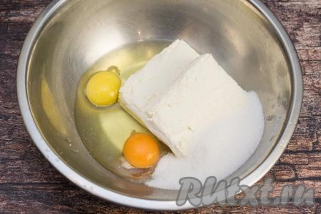 Пока тыква запекается, можно заняться творожной частью запеканки. Для этого в глубокую миску нужно выложить творог, 3 столовых ложки сахара и 2 сырых яйца.