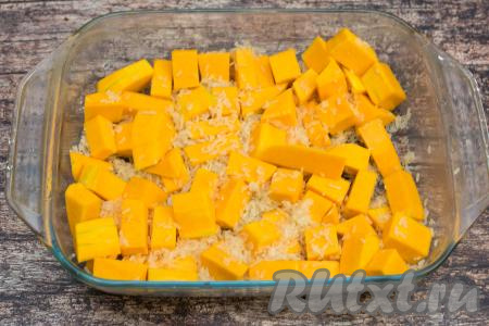 Выложить тыкву в жаропрочную форму, всыпать промытый рис, посолить по вкусу, немного перемешать.