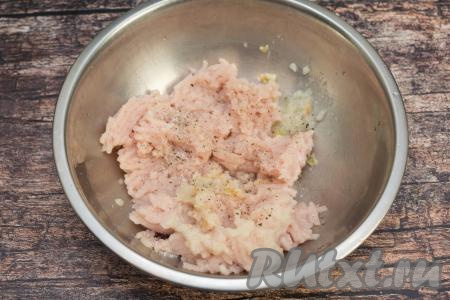 К мясному фаршу добавить очищенный лук, пропущенный через мясорубку (или прокрученный в измельчителе, или очень мелко нарезанный), всыпать соль и чёрный молотый перец, тщательно перемешать.
