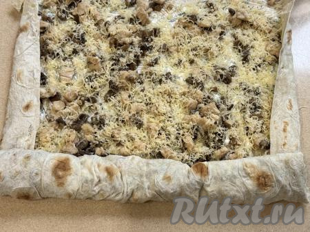 Боковые края лаваша немного подвернуть на начинку из курицы и грибов. Начиная с более узкого края, свернуть лаваш в плотный рулет.