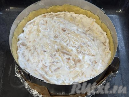 Достать форму с основой для пирога из холодильника. Я сразу поставила форму на противень. Поверх основы из песочного теста для пирога равномерно выложить начинку из яблок и взбитых беков.