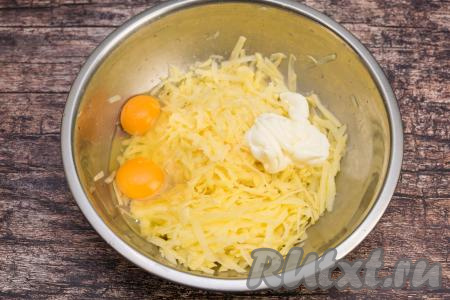 Картофель очистить от кожуры, промыть водой, натереть на крупной тёрке в глубокую миску. В миску с натёртой картошкой добавить сырые яйца и 50 грамм майонеза (примерно 1,5 столовых ложки).