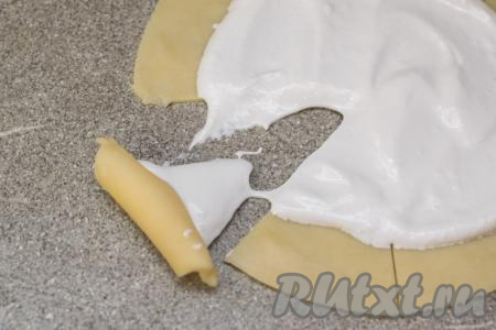Начиная с широкой стороны каждого сектора, свернуть каждый сектор из теста в рулетик. Сворачивайте рогалик неплотно, чтобы взбитые белки сильно не вытекали.