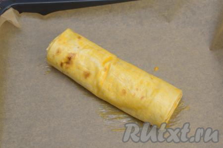 Ранее отложенный желток взболтать кулинарной кисточкой до однородности, получившейся массой смазать поверхность штруделя.