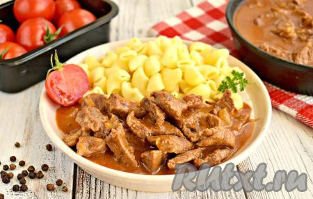 После того как мясо станет мягким, убираем вкусный, ароматный гуляш с огня, даём настояться под крышкой в течение минут 10. А затем нежные кусочки говядины вместе с луком и насыщенной томатной подливкой раскладываем по тарелкам и, дополнив гарниром (в этот раз у меня макароны), в горячем виде подаём к столу.