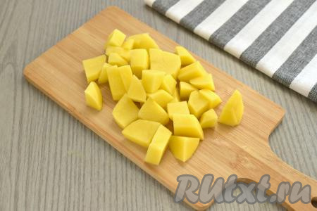 Ставим кастрюлю с процеженным говяжьим бульоном на огонь, даём закипеть. Пока закупает бульон, очищаем и нарезаем картофель на небольшие кубики. В кастрюлю с закипевшим бульоном выкладываем картошку, солим по вкусу.