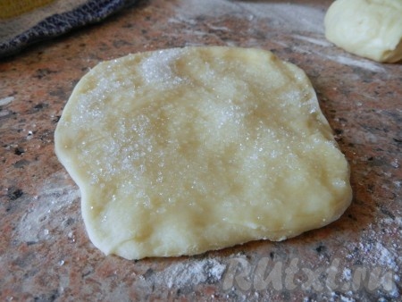Небольшой кусочек теста руками размять в лепешку. Смазать поверхность лепешки растительным маслом, посыпать сахаром.