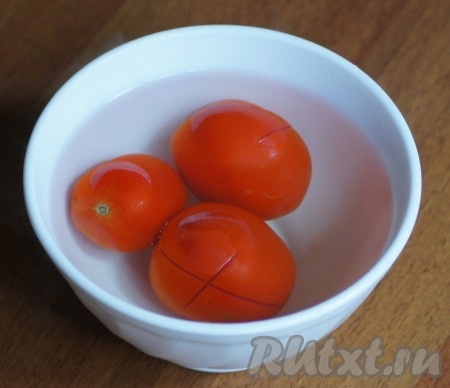 На помидорах сделать надрез, залить их кипятком на 1 минуту, затем шкурка с помидоров снимется одним движением.
