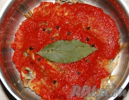 На лук выложить половину томатного соуса, покрывая мойву ровным слоем, лавровый лист и горошины чёрного перца.
