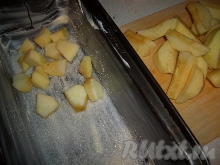 Дно формы смазать сливочным маслом, равномерно посыпать 3 чайными ложками сахара. Выложить яблочные дольки. Поставить форму в разогретую духовку (200 градусов) на 10 минут.
