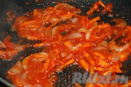 Нарезать очищенные морковь с репчатым луком некрупной соломкой, добавить томатную пасту и обжарить на растительном масле на среднем огне, помешивая время от времени, до полуготовности (на это потребуется 5-7 минут).